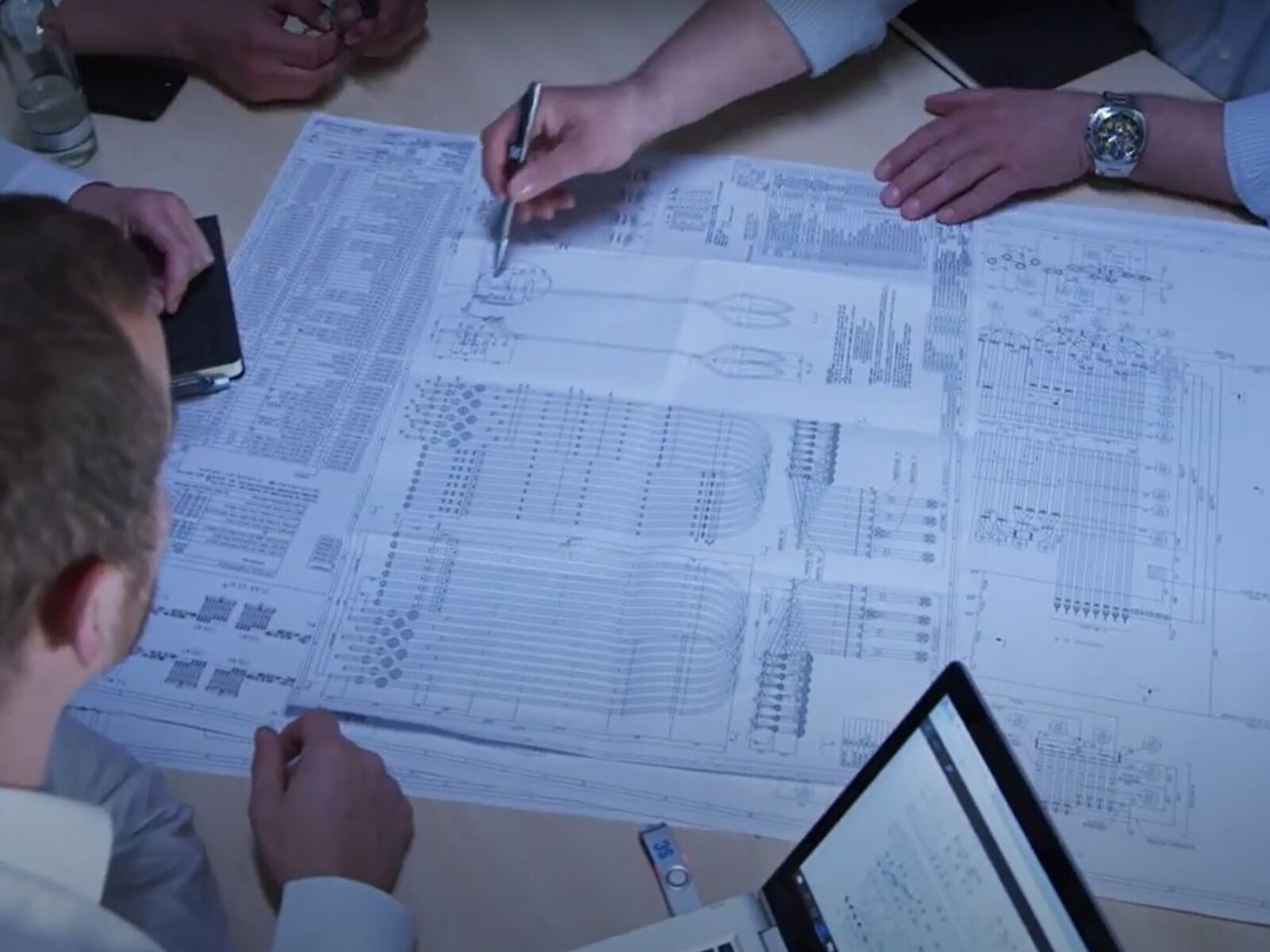 a group of people looking at a paper planning a plant shutdown